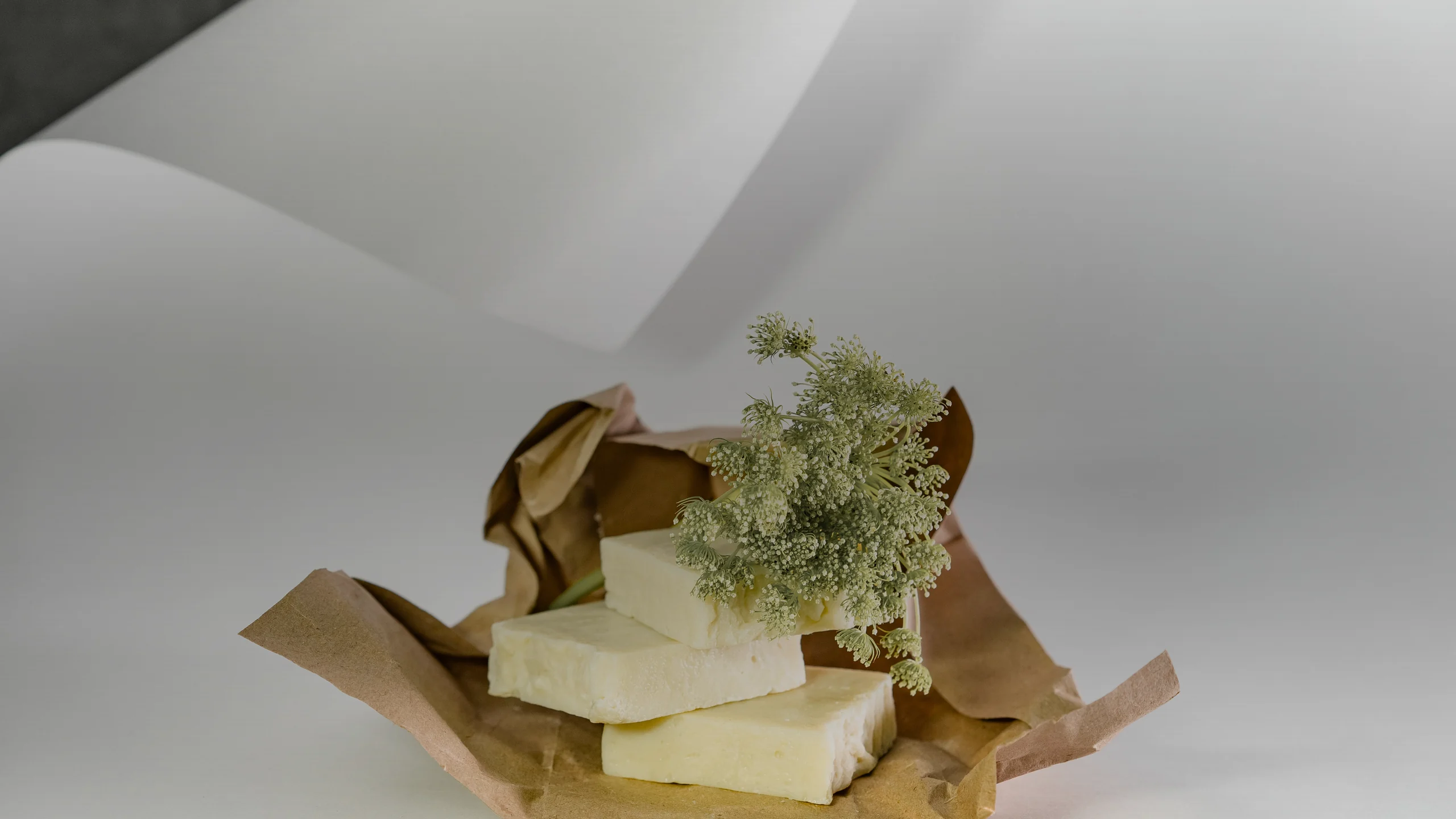 Pains de savon crème sur du papier kraft avec une fleur séchée